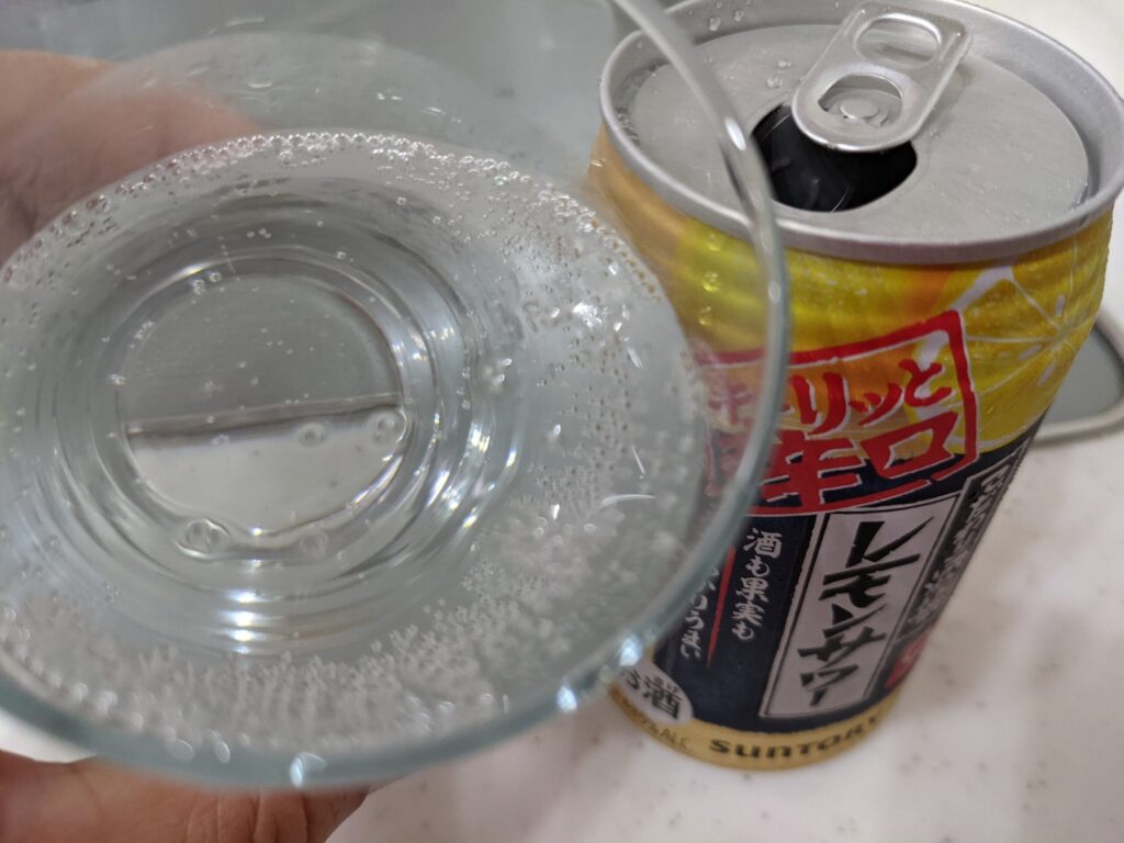 グラスに注いだ「こだわり酒場のレモンサワーキリッと辛口」を飲むところ