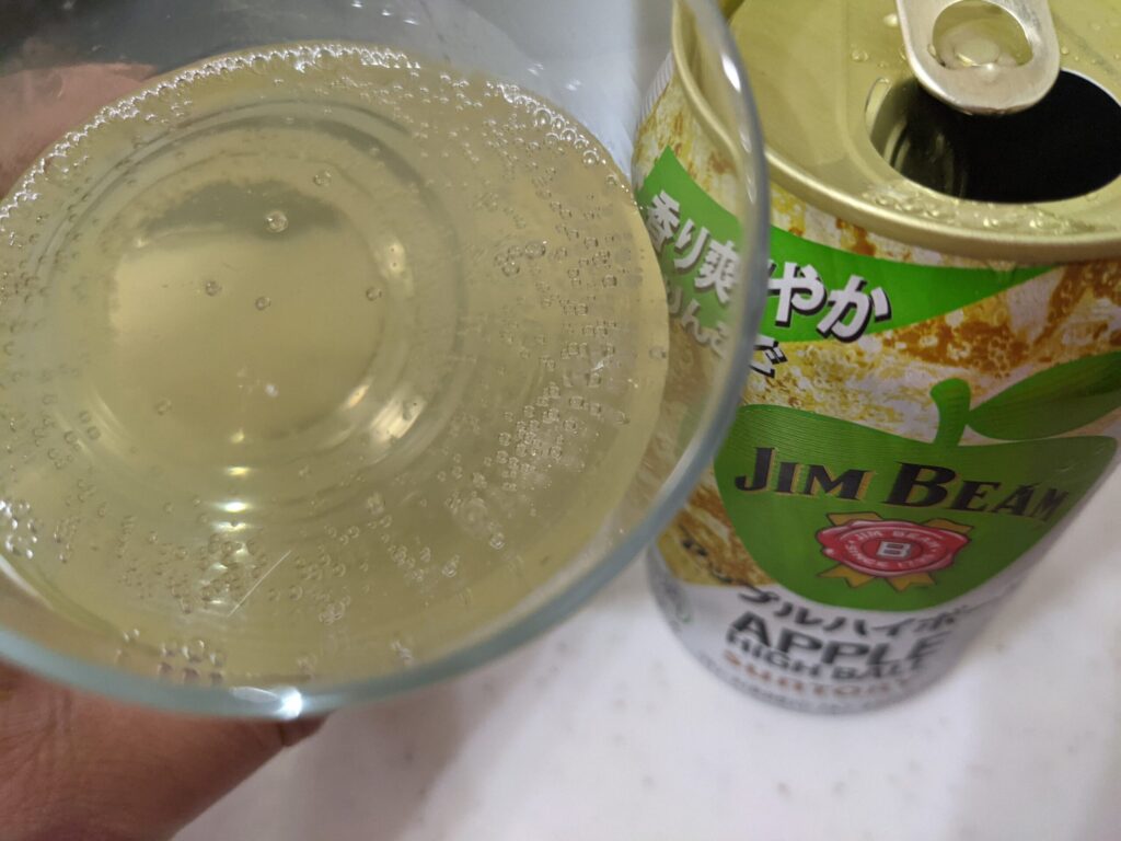 グラスに注いだ「アップルハイボール（ジムビーム）」を飲むところ